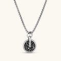 Round 925 sterling silver medallion charm with black enamel fill, scrollwork engraving, rope border, and bold bail ring.