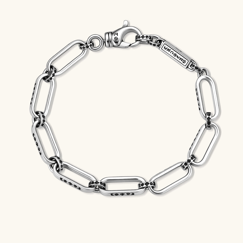 Sterling silver bar-link chain bracelet with oxidized Gothic text engravings and toggle clasp, 7.3mm wide, on white background.