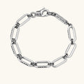 Sterling silver bar-link chain bracelet with oxidized Gothic text engravings and toggle clasp, 7.3mm wide, on white background.