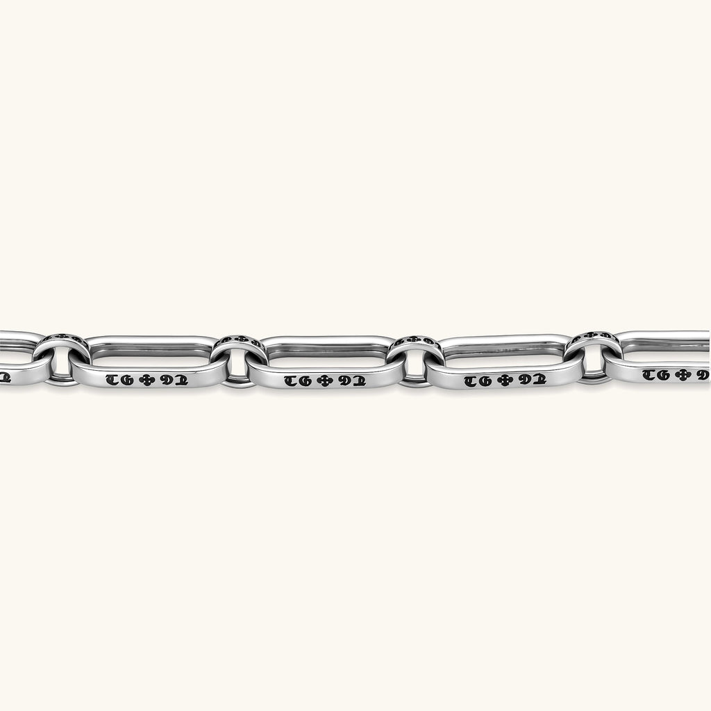 Sterling silver bar-link chain bracelet with oxidized Gothic text engravings and toggle clasp, 7.3mm wide, on white background.