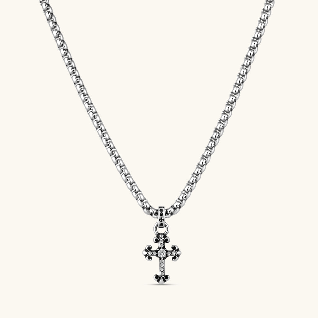 Sterling silver gothic cross pendant with ornate fleur-de-lis tips, pavé crystals, and center stone on a box chain.