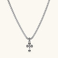 Sterling silver gothic cross pendant with ornate fleur-de-lis tips, pavé crystals, and center stone on a box chain.