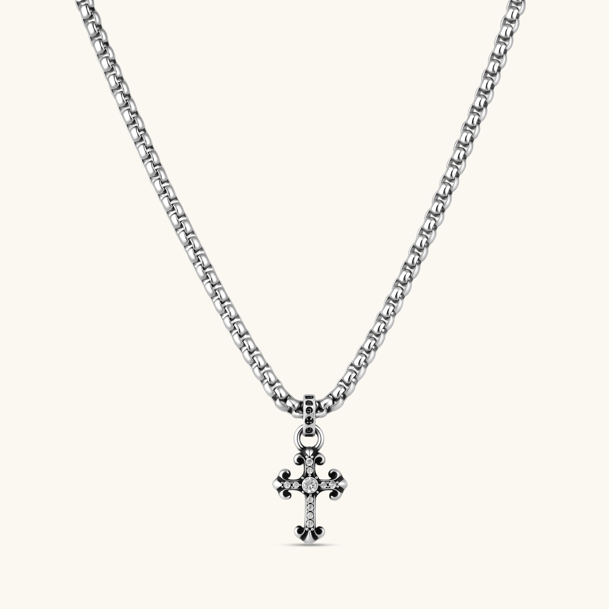 Sterling silver gothic cross pendant with ornate fleur-de-lis tips, pavé crystals, and center stone on a box chain.