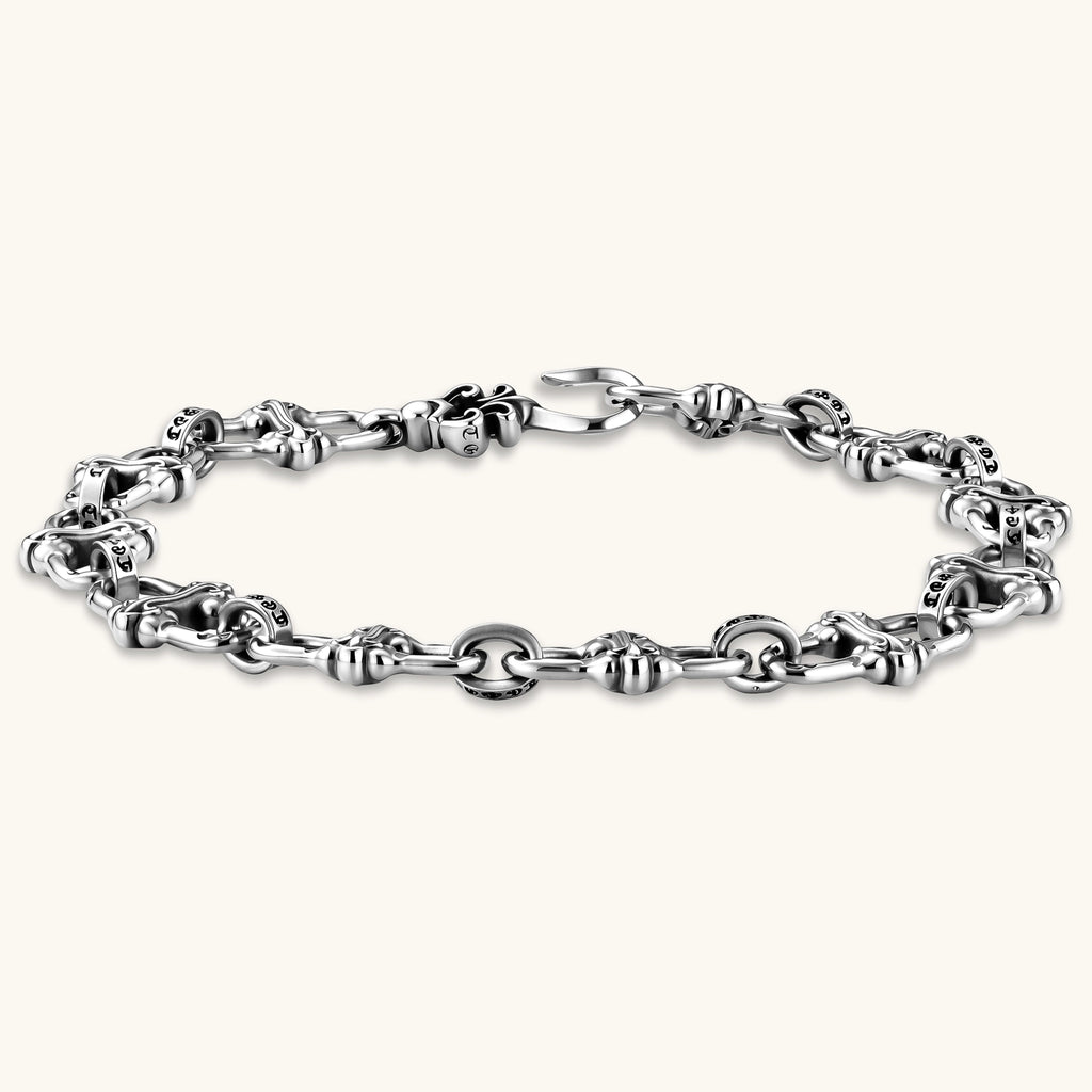 Sterling silver link bracelet with fleur-de-lis cross motifs, oxidized detailing, and hook clasp, 200mm length.