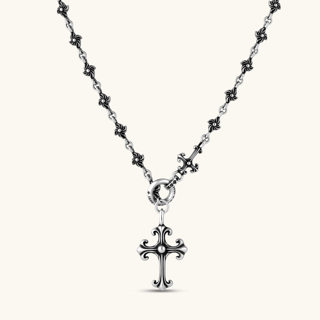 Sterling silver necklace with ornate floral-link chain, ring clasp, cross toggle bar, and Gothic fleur cross pendant.
