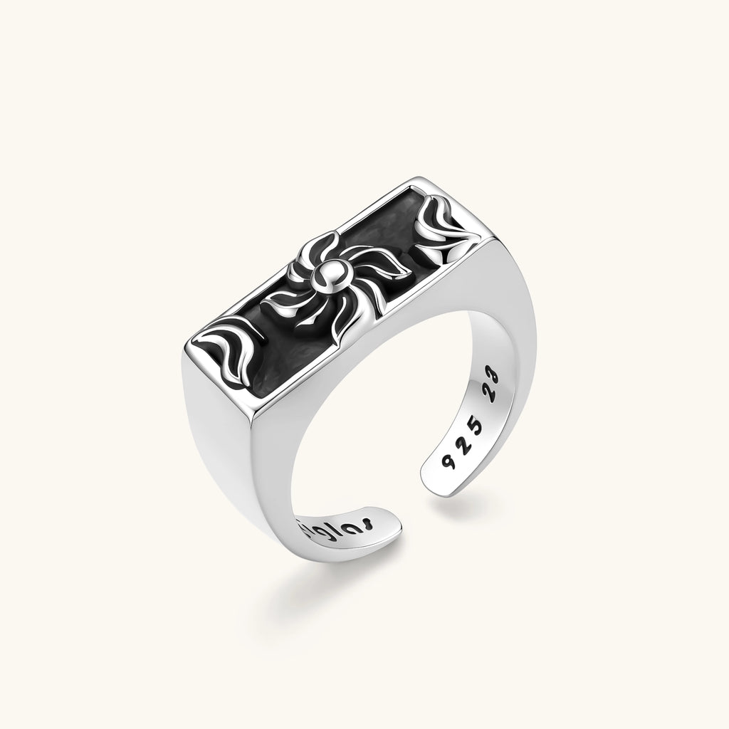 925 sterling silver open signet ring with rectangular black enamel face and raised silver sun-spider motif, adjustable band.