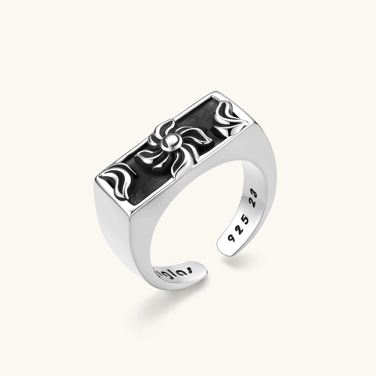 925 sterling silver open signet ring with rectangular black enamel face and raised silver sun-spider motif, adjustable band.