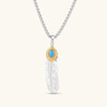 Sterling silver feather pendant with gold-tone base and oval turquoise cabochon, detailed quill engraving, 67mm length.