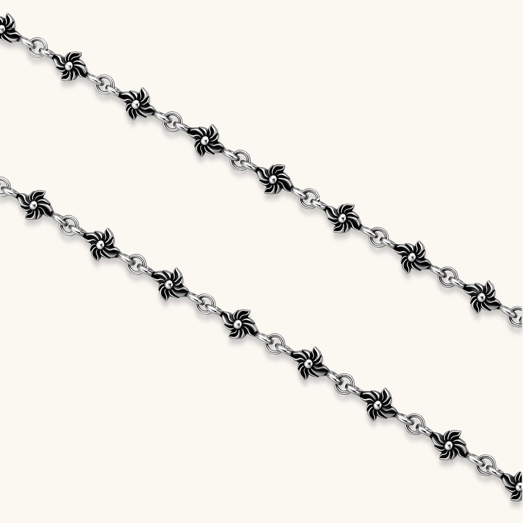 Sterling silver necklace with ornate floral-link chain, ring clasp, cross toggle bar, and Gothic fleur cross pendant.