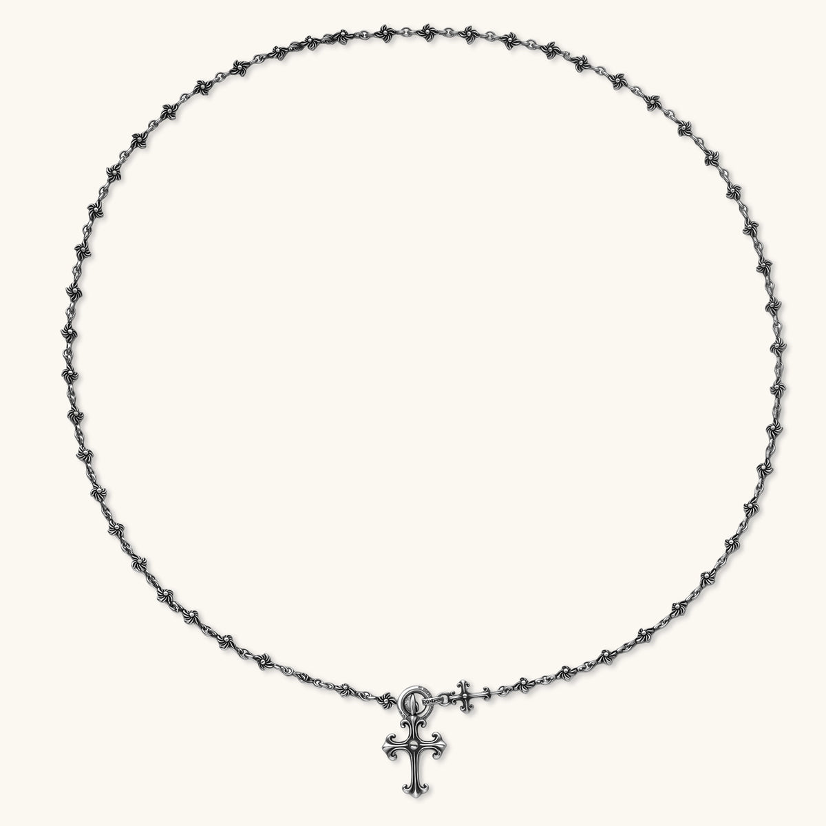Sterling silver necklace with ornate floral-link chain, ring clasp, cross toggle bar, and Gothic fleur cross pendant.