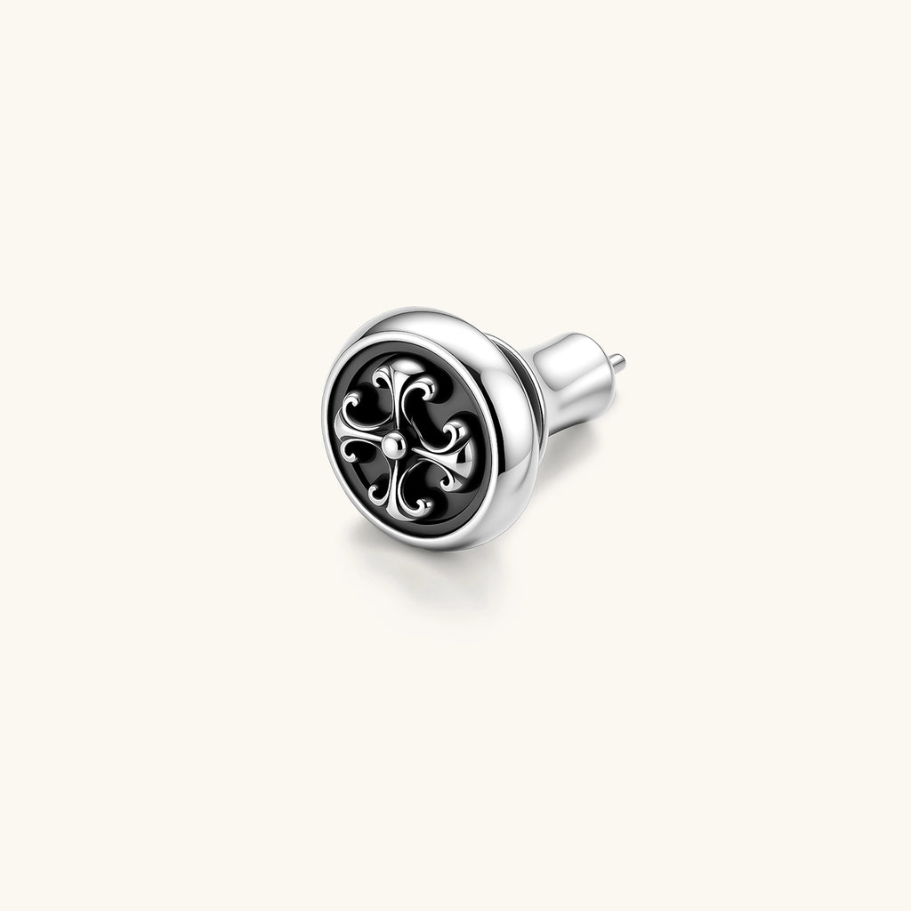 Round sterling silver stud earring with black enamel background and fleur-de-lis cross motif, butterfly push-back closure.